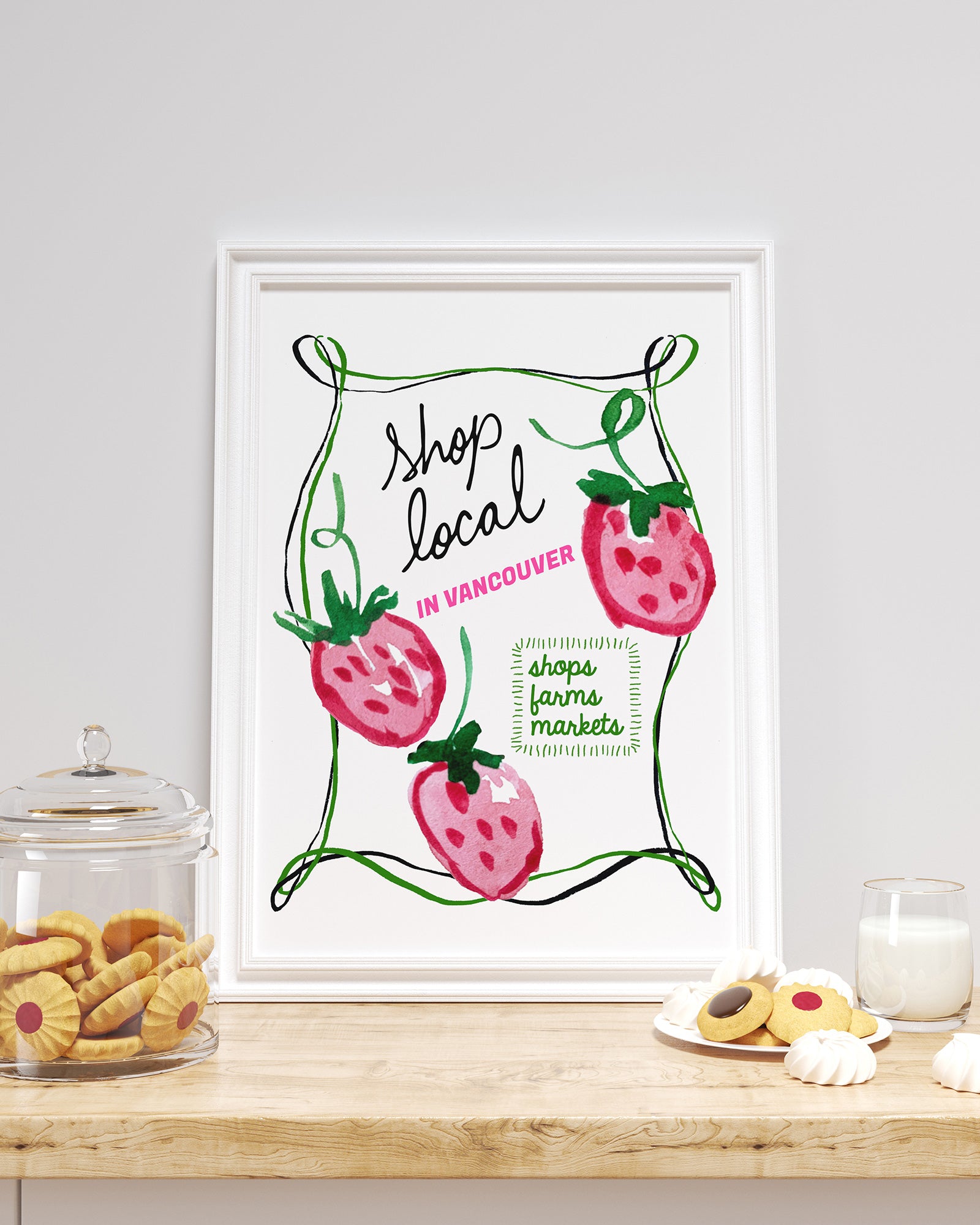Framed artwork with strawberry design and text on a kitchen counter.